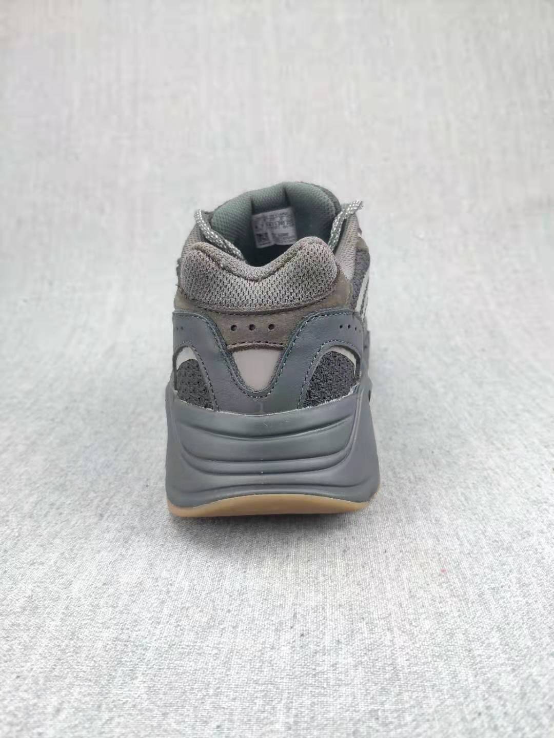 Rear view of a gray sneaker showing the padded collar, heel panels, and thick outsole.