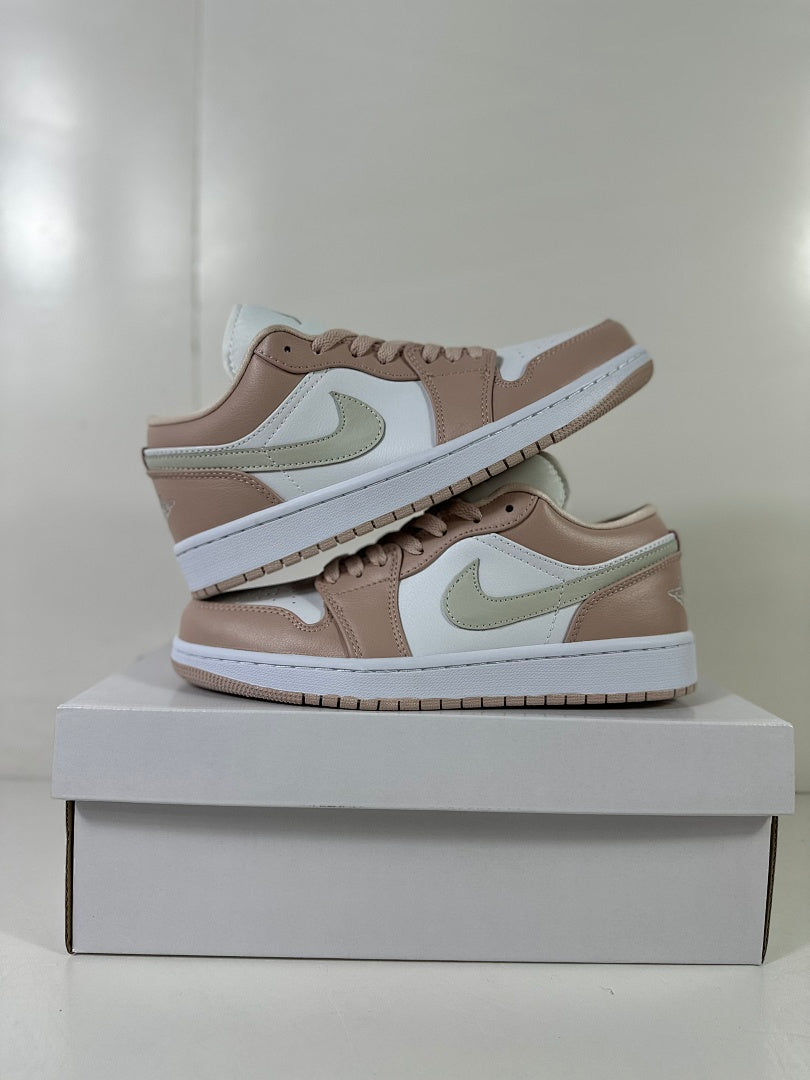 Pair of Jordan Air Jordan 1 Low sneakers stacked on a white shoebox, showing the side panels and outsole edges.