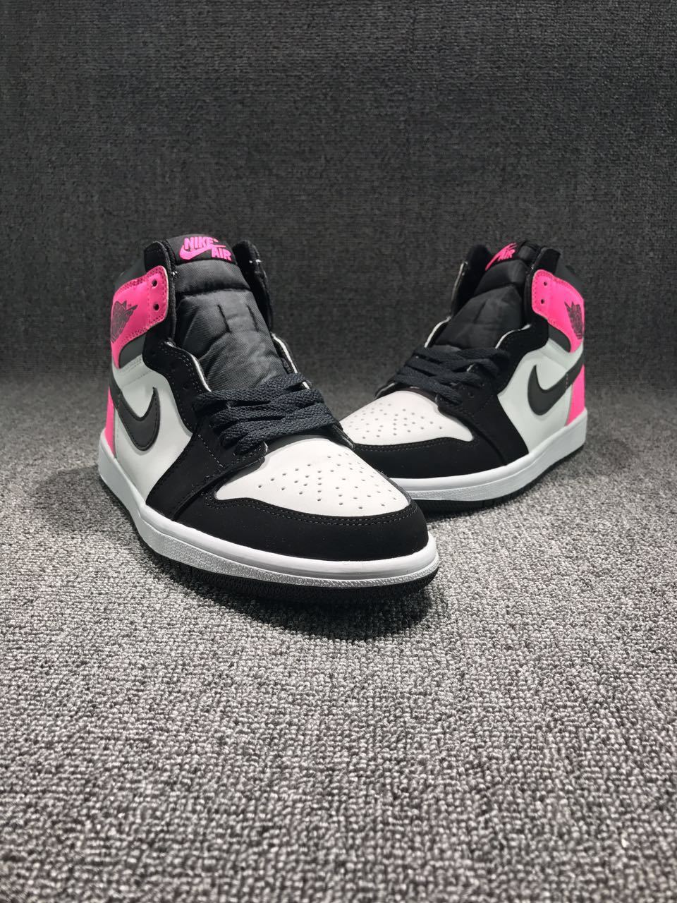 Front three-quarter view of the pair with white perforated toe boxes, black overlays and laces, and pink collar accents.