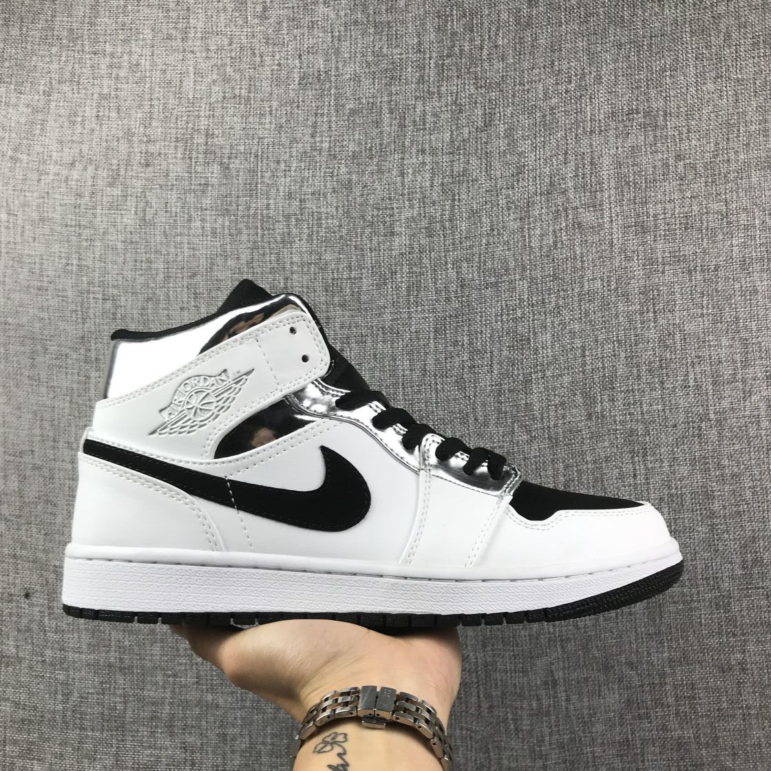 Side view of a white, black, and metallic silver Jordan mid-top sneaker.