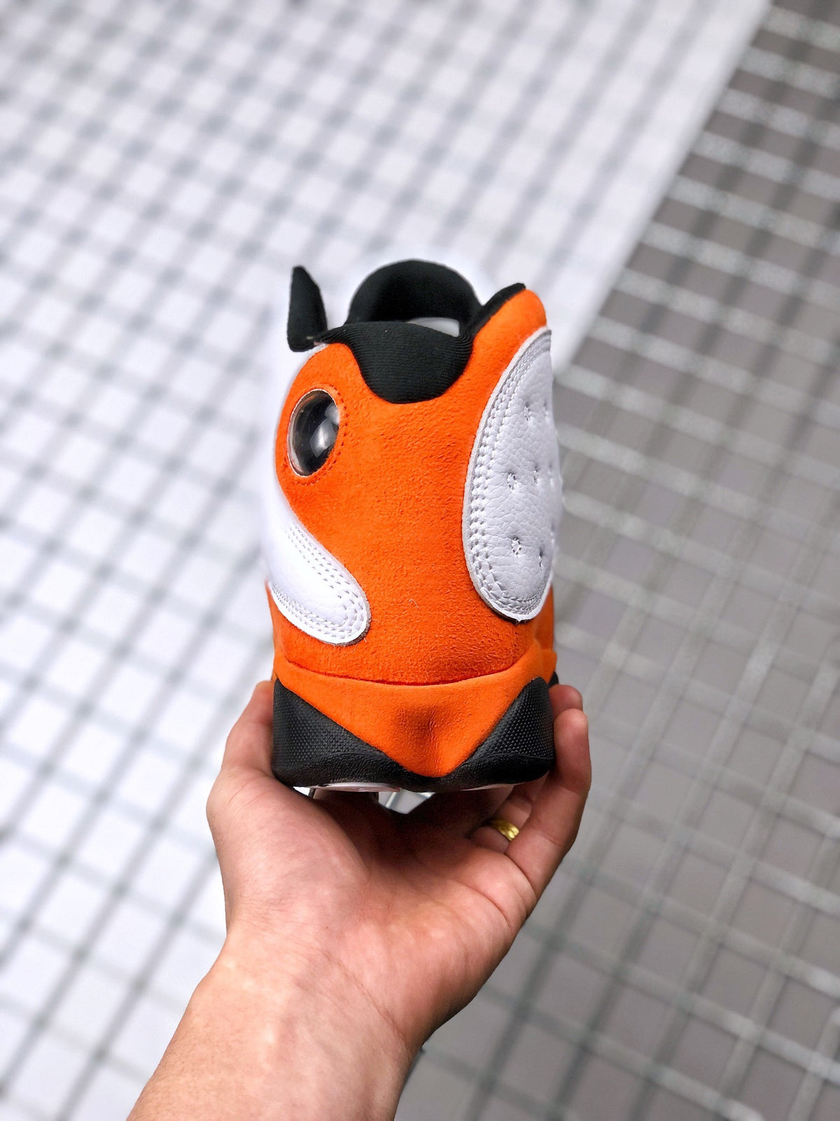 Rear view of the Air Jordan 13 heel in orange, white, and black