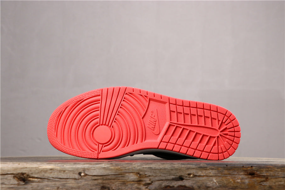 Underside view showing the bright red rubber outsole and its circular and grid traction pattern.