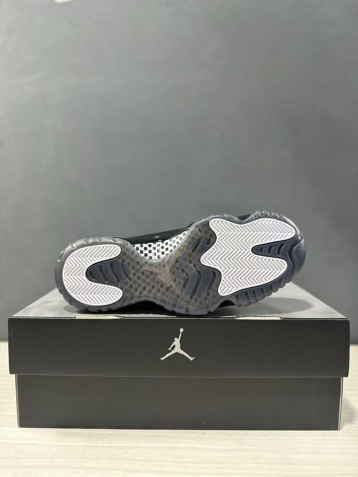 Bottom view of the sneaker showing the translucent gray outsole and white-and-gray traction pattern.