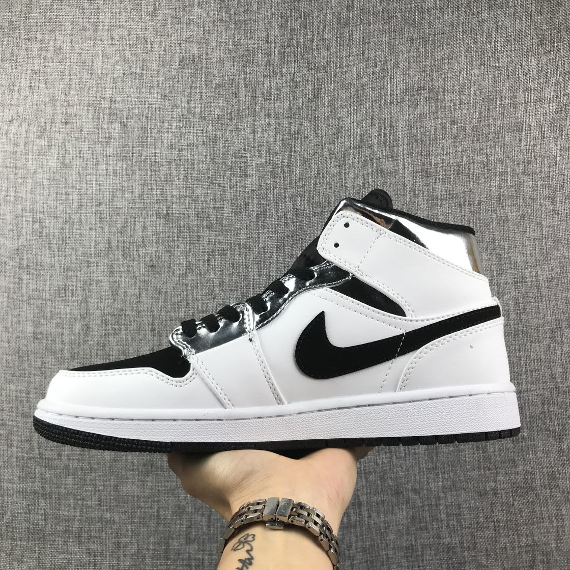 Opposite side view showing the black Swoosh, white panels, and metallic silver eyelet area.
