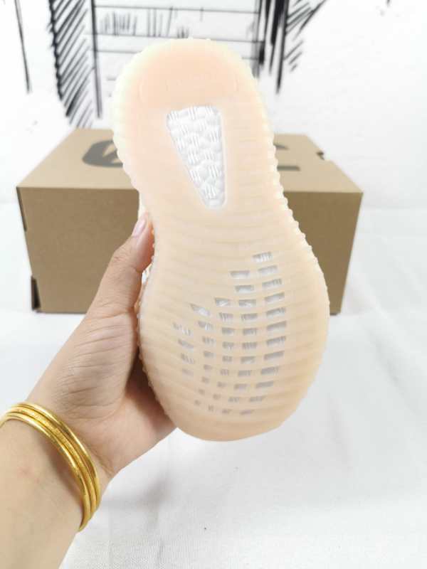 View of the translucent ribbed outsole and heel of a linen-yellow kids’ sneaker.