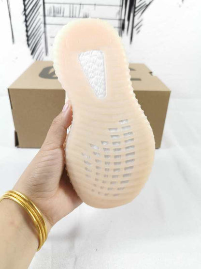 View of the translucent ribbed outsole and heel of a linen-yellow kids’ sneaker.