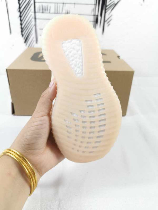 View of the translucent ribbed outsole and heel of a linen-yellow kids’ sneaker.