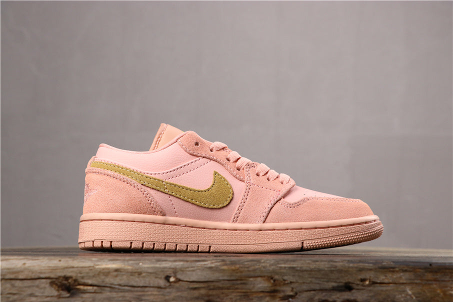 Side profile of the coral pink low-top sneaker showing the gold-toned side emblem, layered panels, low collar, and rubber outsole.