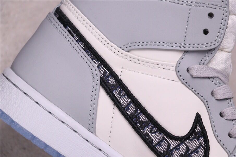 Detailed side view of the grey heel overlay, stitching and patterned Swoosh.
