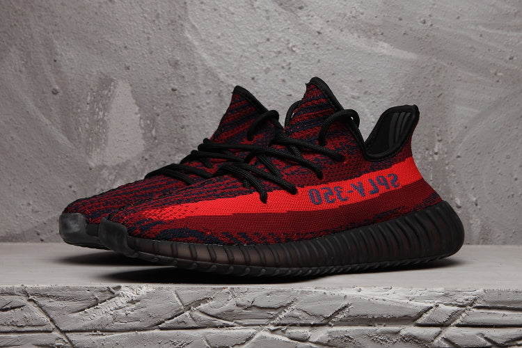 Pair of red and black knit sneakers shown from a three-quarter front angle.