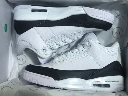 A pair of white and black Jordan 3 sneakers arranged inside the box.