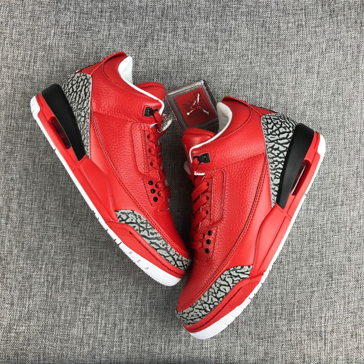 Pair of red Air Jordan 3 sneakers shown from above at an angle.