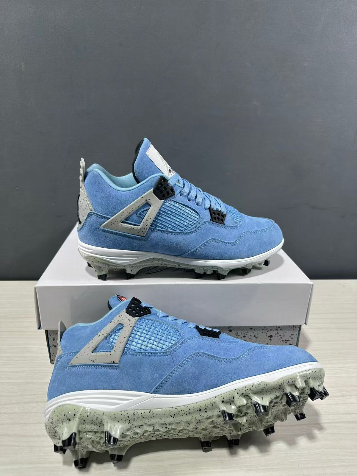 Angled view of the sneakers highlighting the blue upper, white midsole, speckled outsole, and black studs.