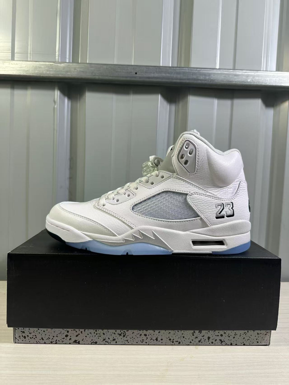 Side profile of a white and silver high-top sneaker with mesh panel and 23 heel detail.