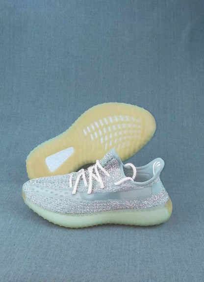 Pair of pale icy Yeezy 350 V2 sneakers, including a view of the translucent yellow-tinted outsole.