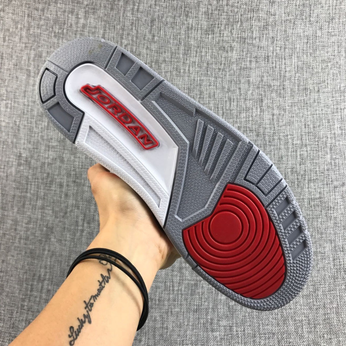 Underside view showing the grey outsole and red traction area