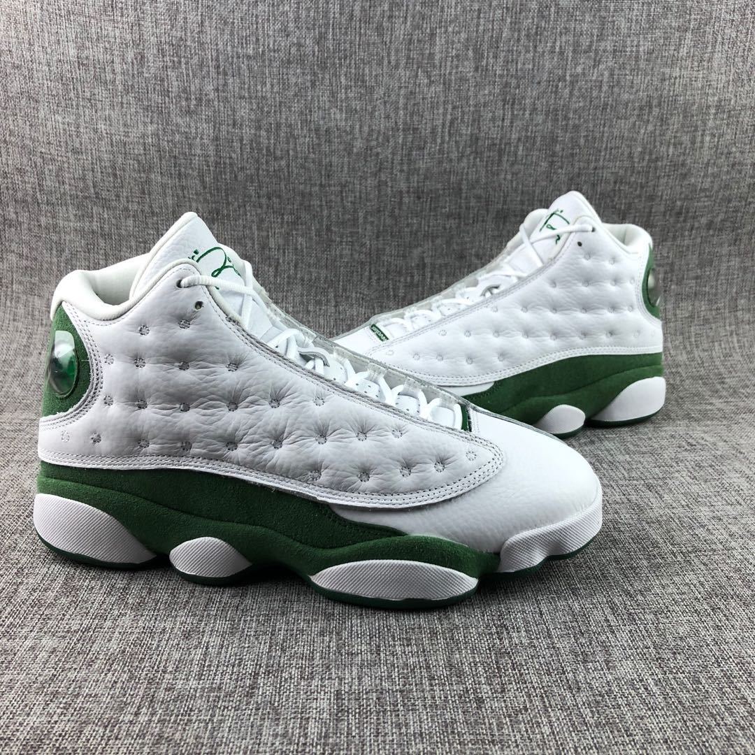 Side profile showing the white upper, textured stitched panel, green midsole, and white outsole sections.