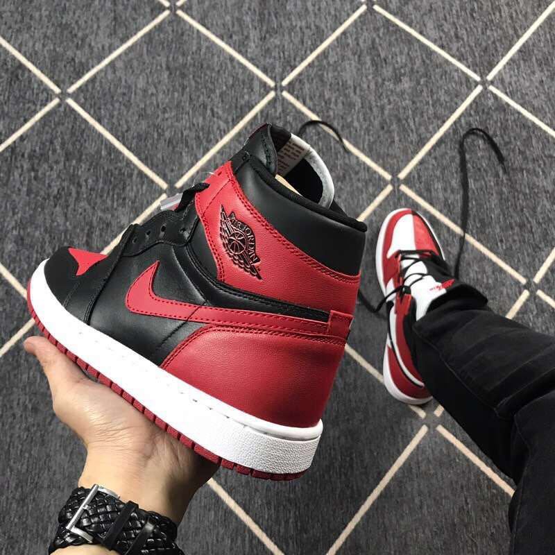 Close side view of a black and red high-top sneaker showing the ankle panel, side Swoosh, and layered outsole.