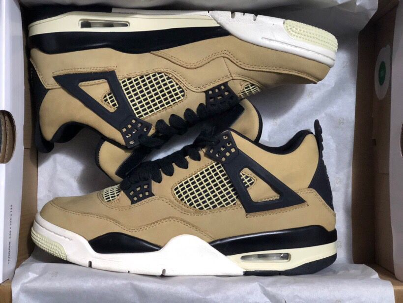 Pair of mushroom-toned Jordan 4 Retro sneakers with black overlays, laces, mesh panels, and contrasting soles inside a box.