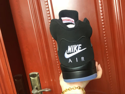 Rear view of a black sneaker showing white Nike Air branding and a translucent blue heel outsole.