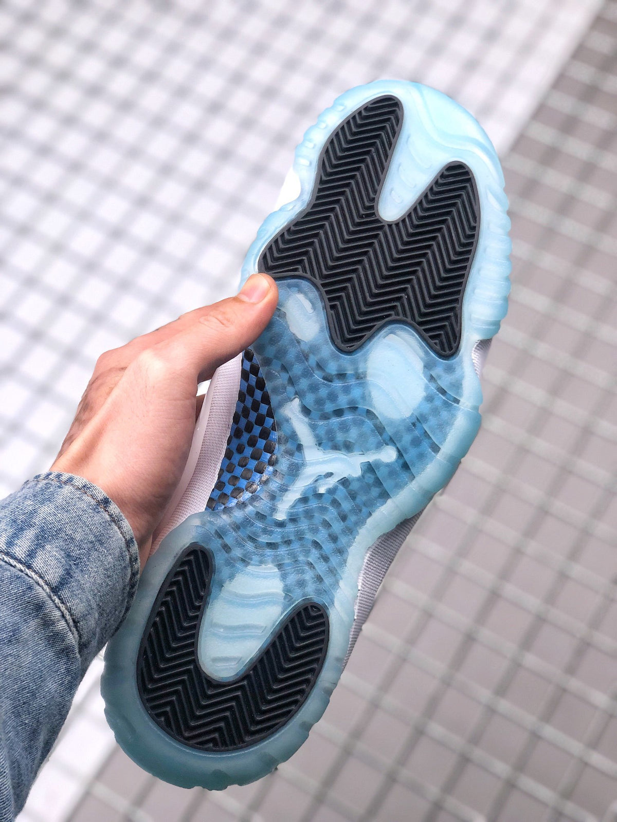 Underside view showing the translucent blue outsole and black herringbone traction sections.