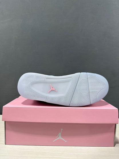 Bottom view of one sneaker showing a mostly white patterned rubber outsole with a pink Jordan logo.