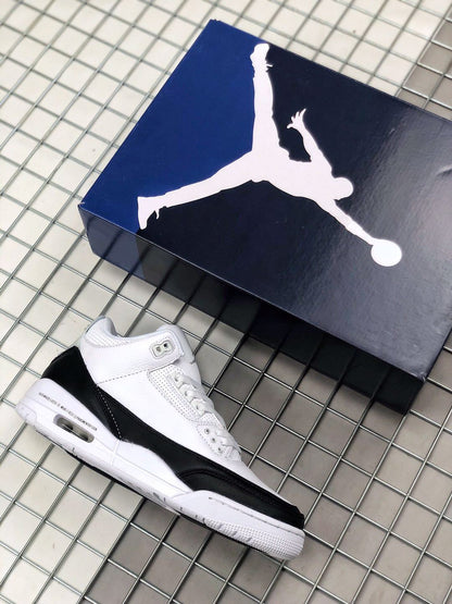 White and black Fragment x Air Jordan 3 sneaker beside a Jordan shoebox.