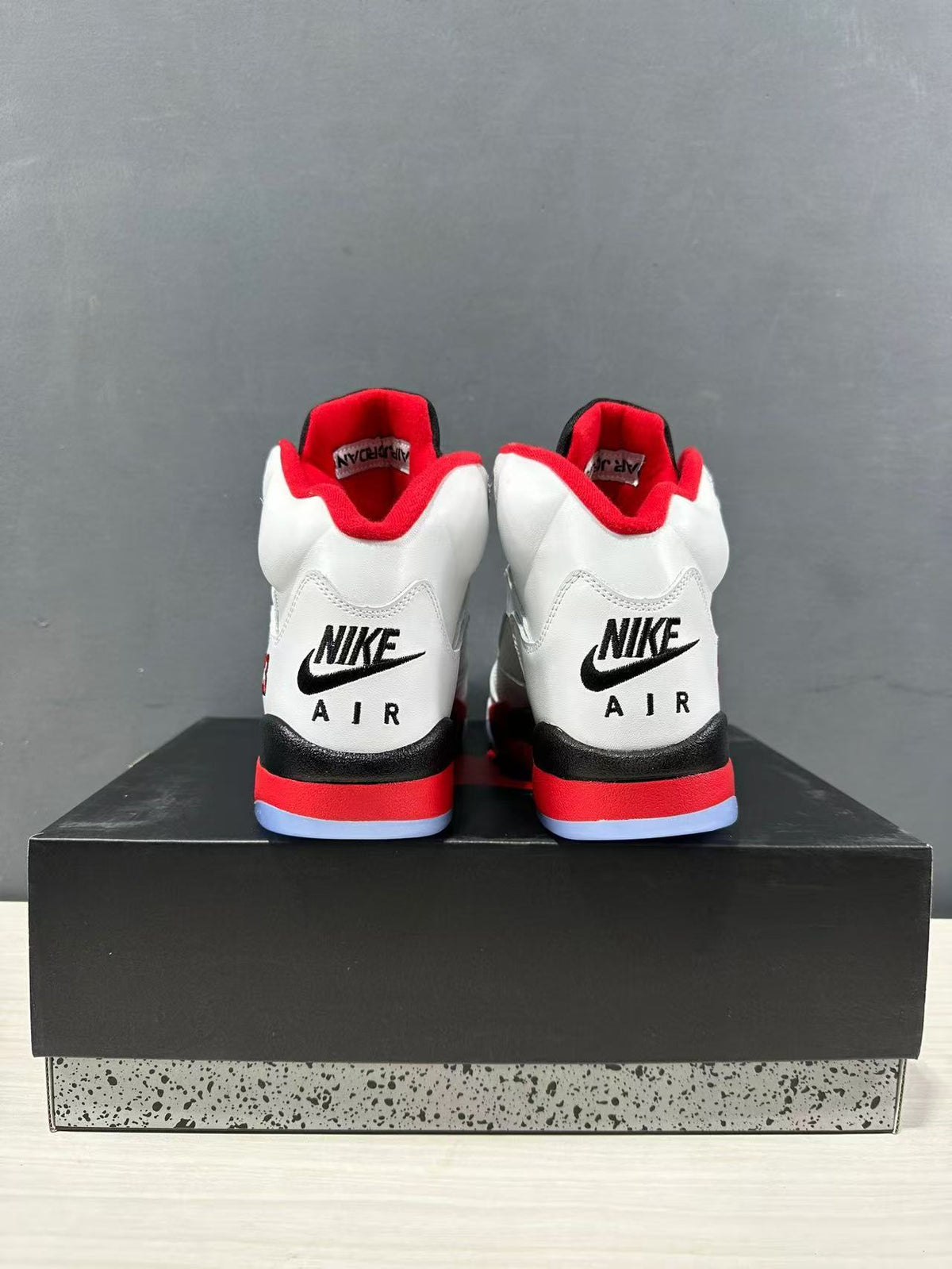 Rear view of the pair showing black heel branding, red midsole accents, and translucent outsole sections.