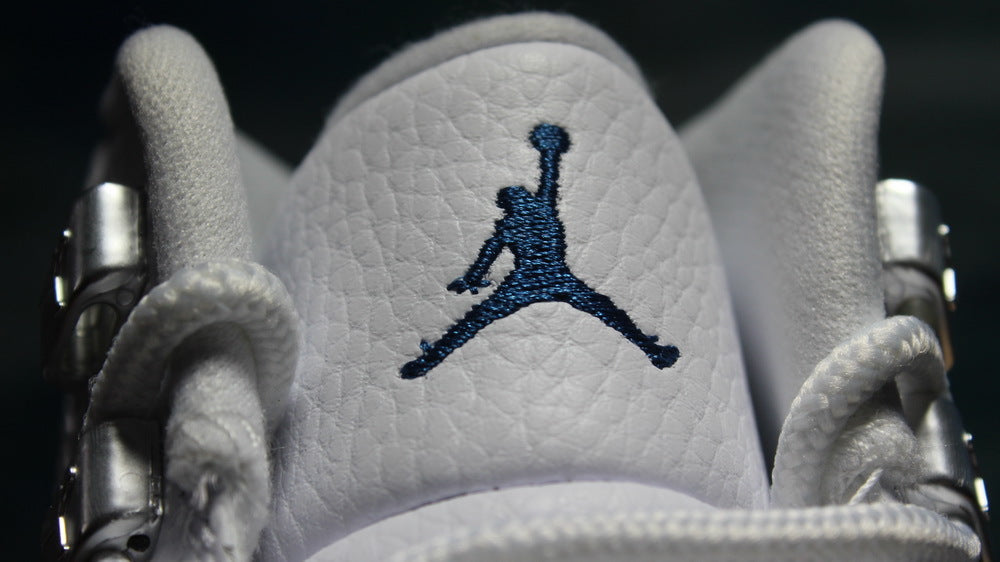 Close-up of the navy Jordan logo embroidered on the white tongue.