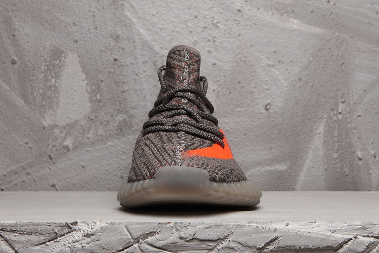 Front view of the grey Yeezy 350 V2 sneaker showing the lacing, knit-style upper, and translucent toe outsole.
