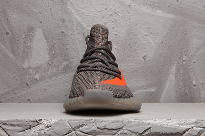 Front view of the grey Yeezy 350 V2 sneaker showing the lacing, knit-style upper, and translucent toe outsole.