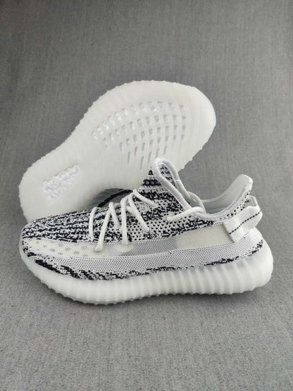 Side view of a black-and-white knit sneaker with the translucent sole visible underneath.