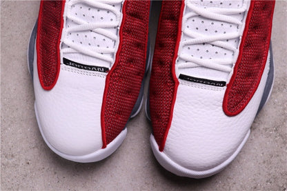 Close-up of the white toe panels, laces, and red patterned overlays.
