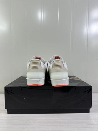 Rear view of the beige and white low-top sneakers showing ribbed heel details and orange outsole accents.