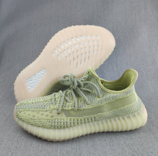 Close-up side view of pale green and blue-gray knit Yeezy 350 V2 sneakers with a translucent ribbed sole.