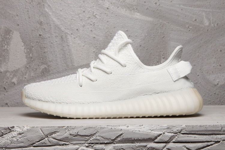 Side profile of a white Yeezy 350 V2 sneaker with a translucent ribbed sole.