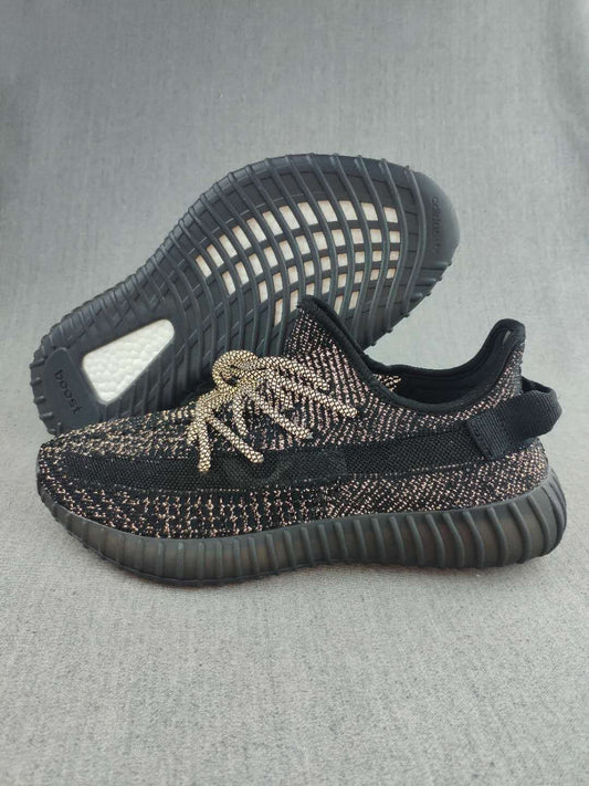 Pair of black Yeezy 350 V2-style sneakers showing the patterned knit upper, matching laces, and ribbed outsole.