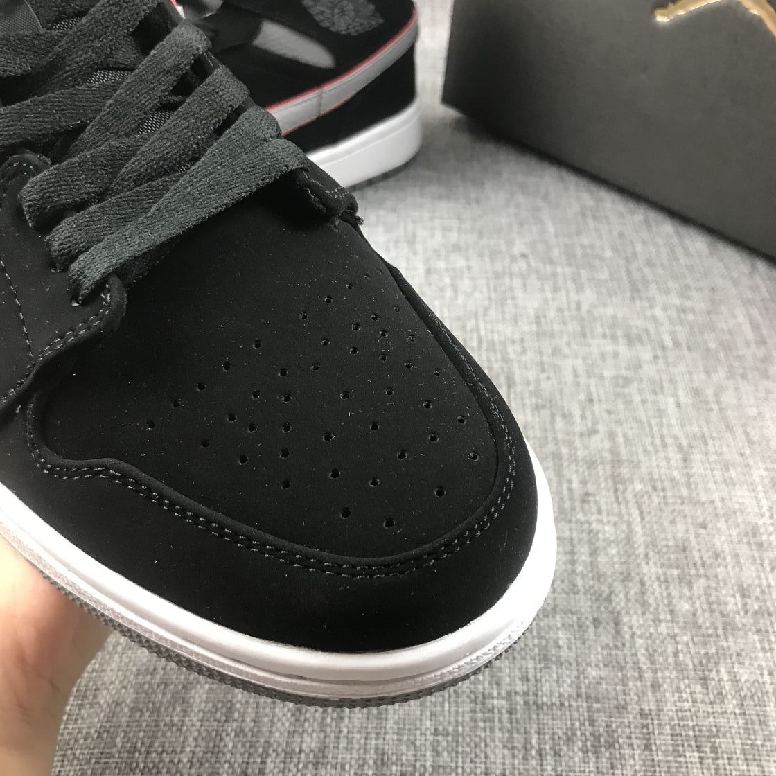 Close-up of the black perforated toe box and black laces.