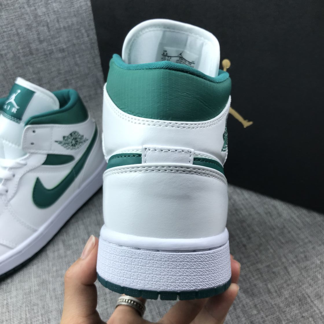 Rear view showing the white heel, green padded collar, and white midsole.