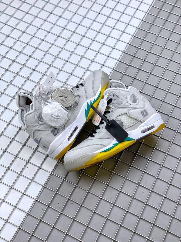 Pair of grey and white high-top sneakers with spare laces and attached tags.