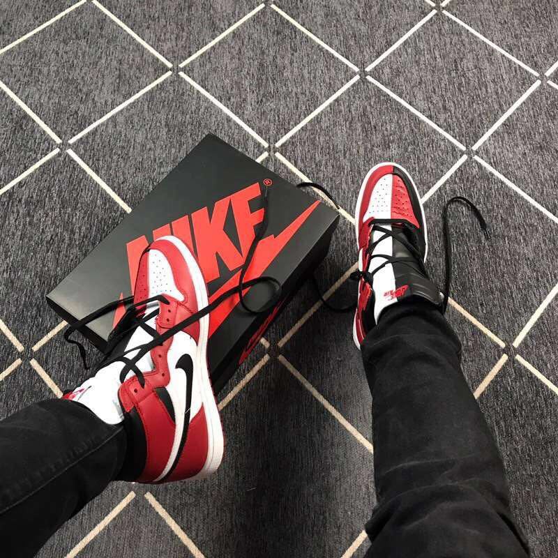 The sneakers being worn beside a black Nike shoe box.