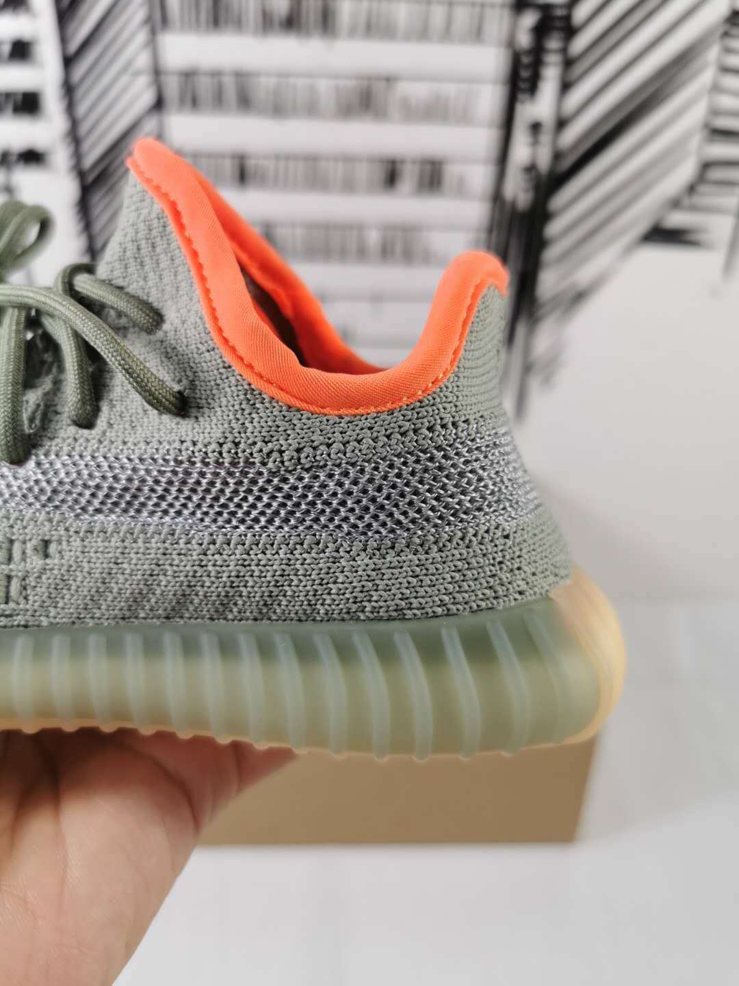 Close-up of the orange padded collar, gray upper, and translucent sidewall of the sole.