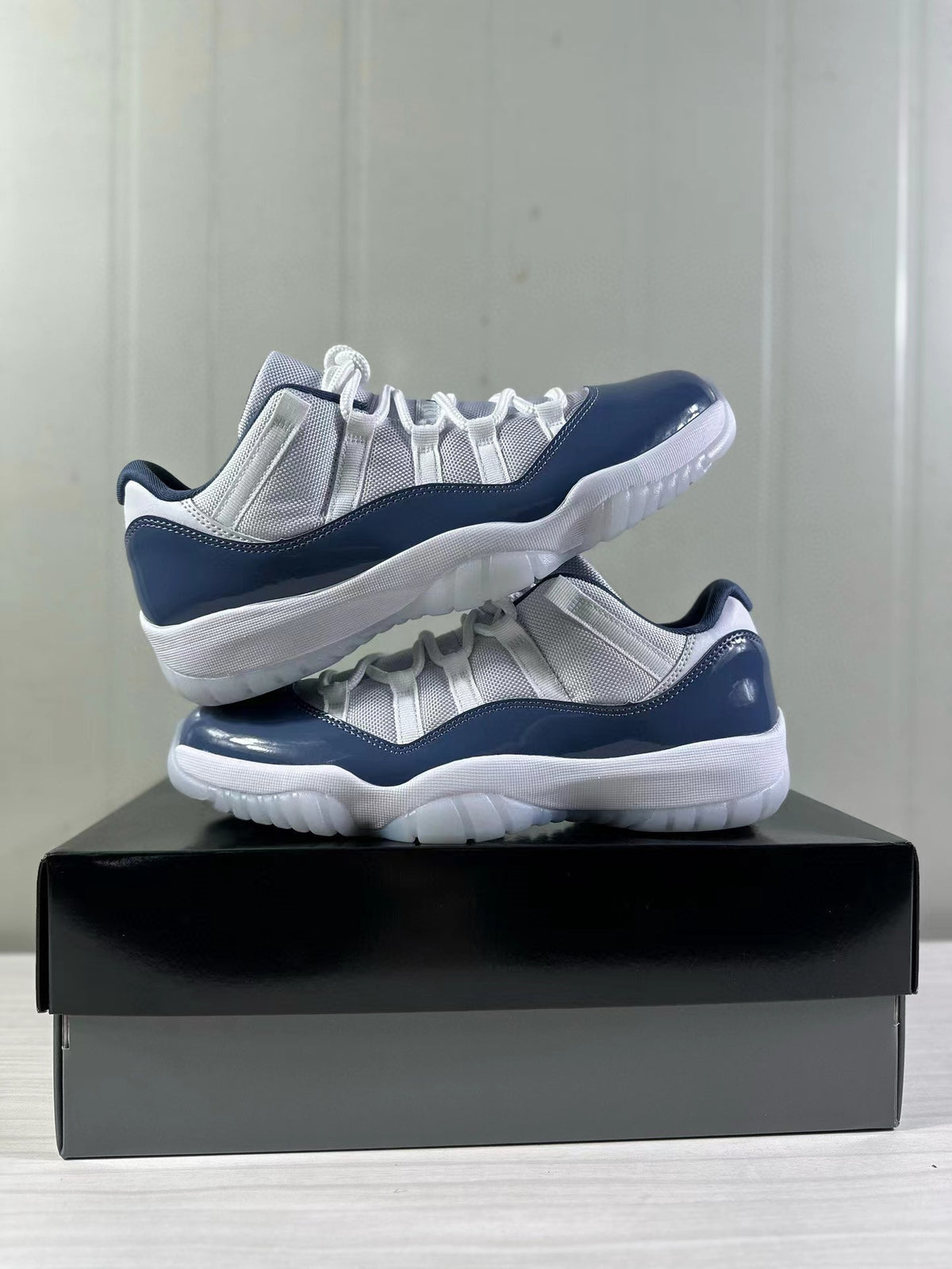 Pair of white and blue Jordan Air Jordan 11 Low sneakers stacked together