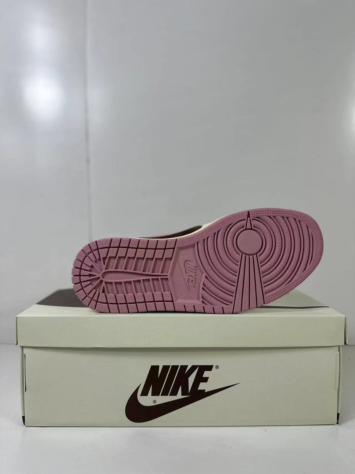 Close view of the pink rubber outsole and circular traction pattern.