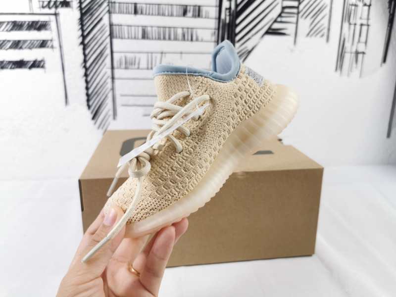 Angled side view of the kids’ sneaker with a linen-yellow upper and translucent sole.