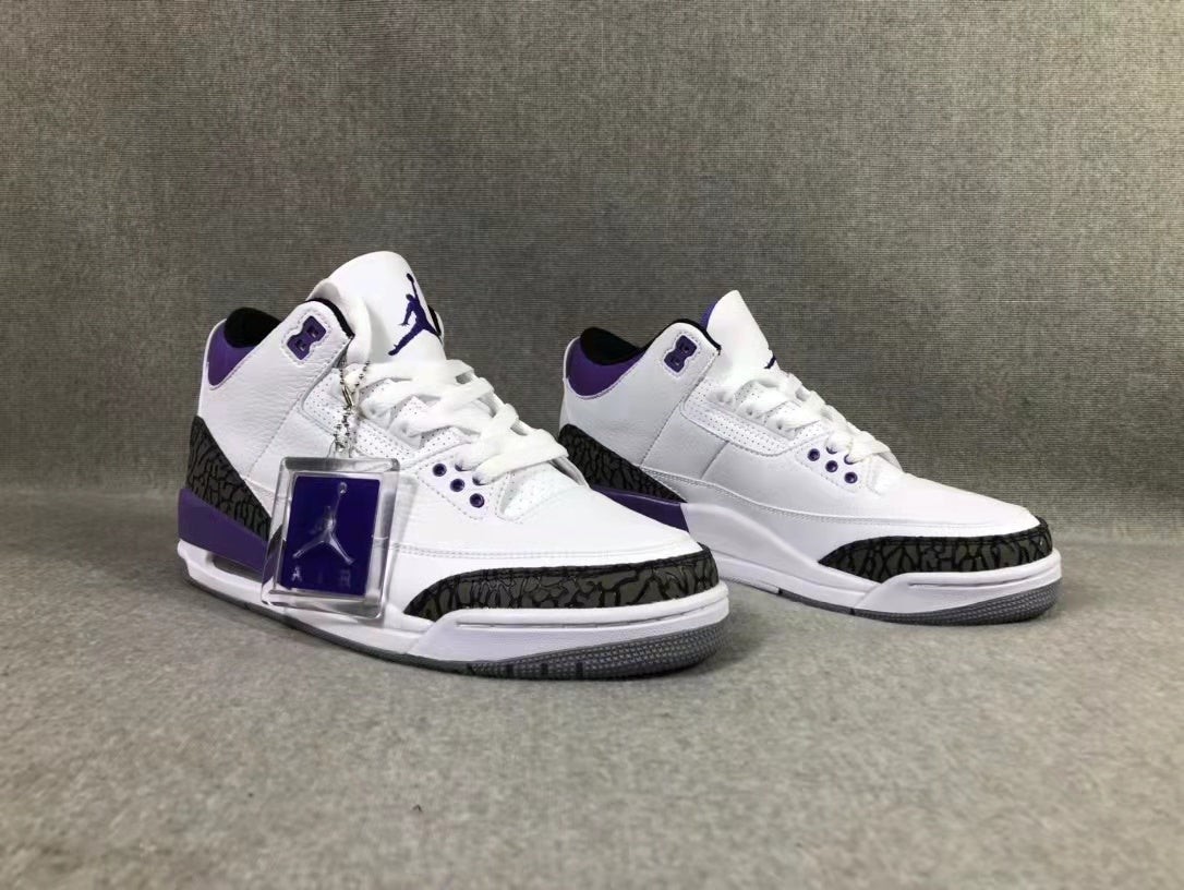 Front three-quarter view of the pair showing the white and purple colorway and patterned toe overlays.