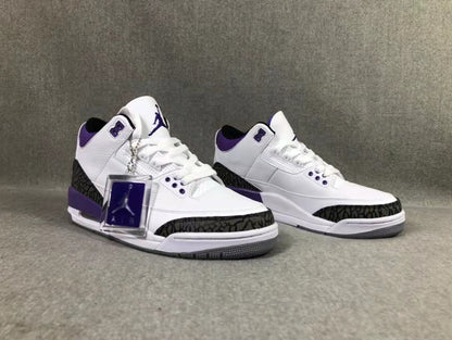 Front three-quarter view of the pair showing the white and purple colorway and patterned toe overlays.