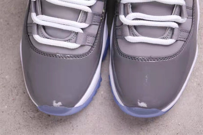 Close-up of the grey patent-style toe sections, white laces, and translucent blue outsole edges.