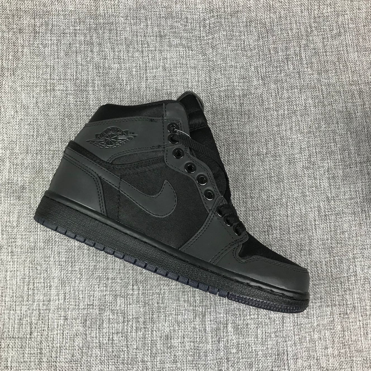 Angled side view highlighting the high-top collar, tonal side branding, and black outsole.