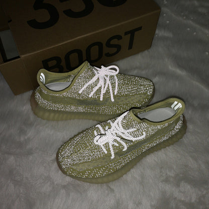 Lifestyle photo of olive green sneakers with reflective-looking laces beside a box visibly marked BOOST.